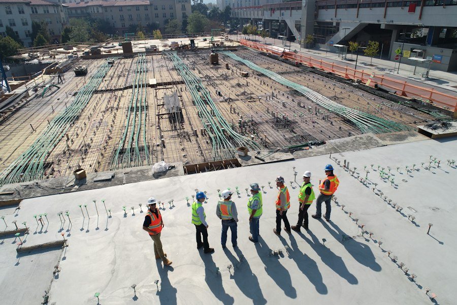 Dva pokrývači pracující na šikmé střeše