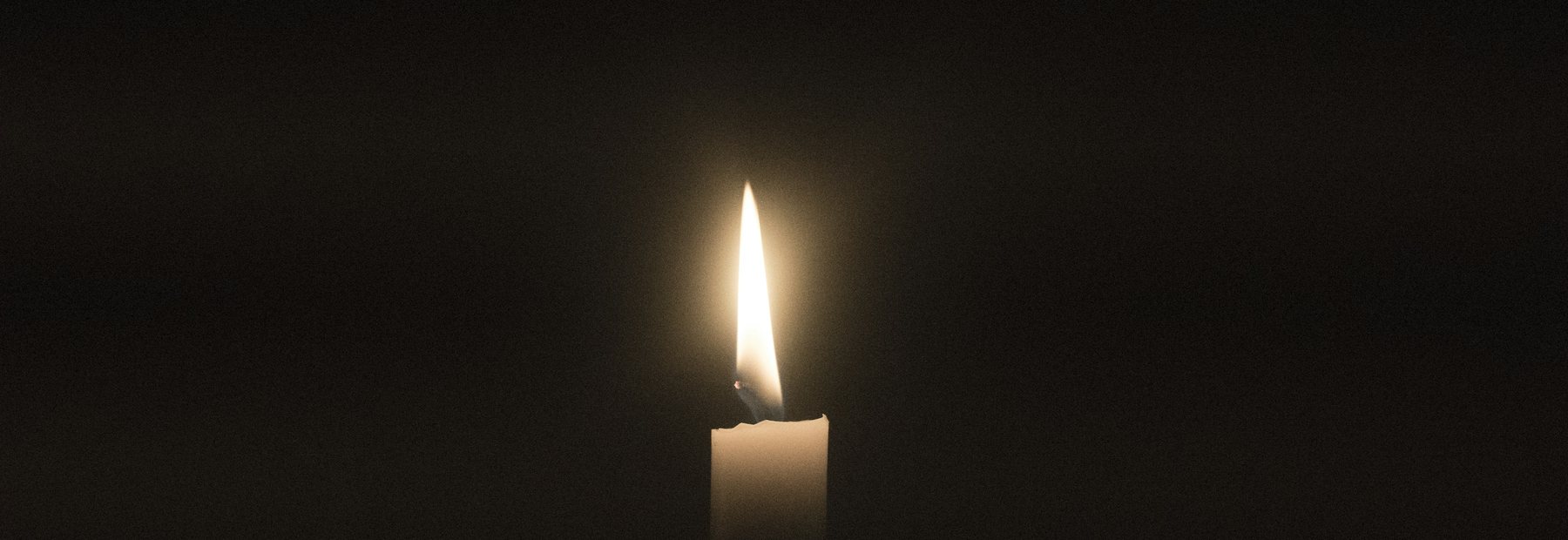 Plamen svíčky v temné místnosti